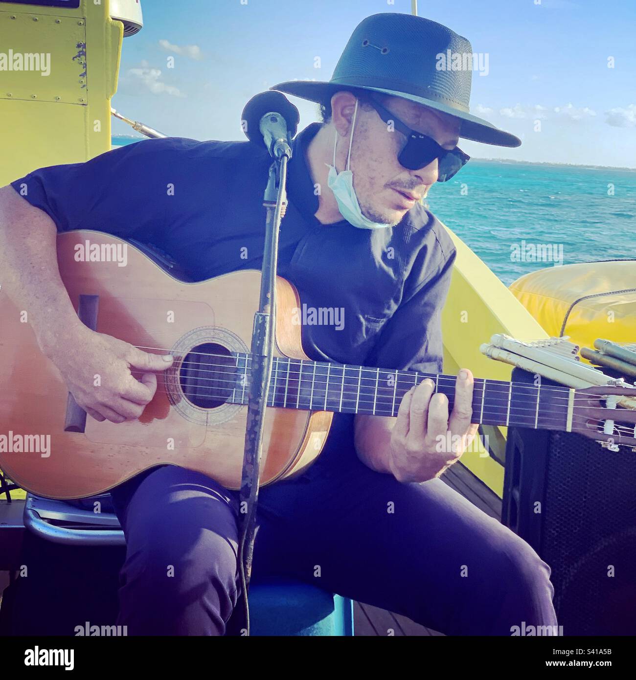Musician performing on an Ultramar ferry from Cancun to Isla Mujeres, Mexico - Smartphone Captured Stock Image