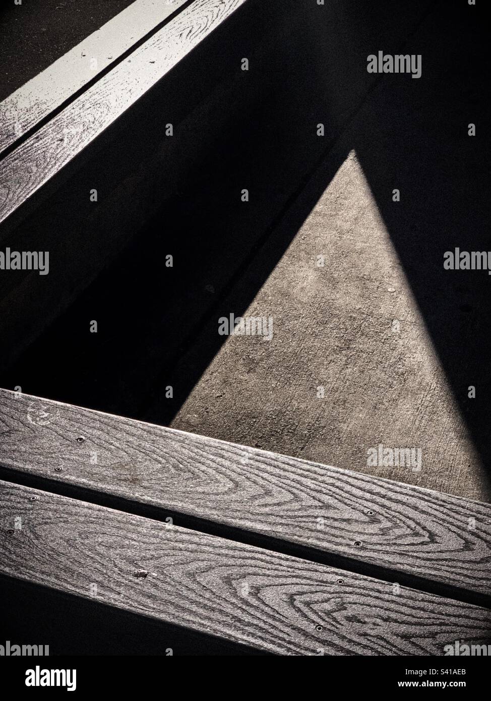 Writing with light to lines, textures, shape and patterns on the triangles of wooden benches and cement floor Stock Photo