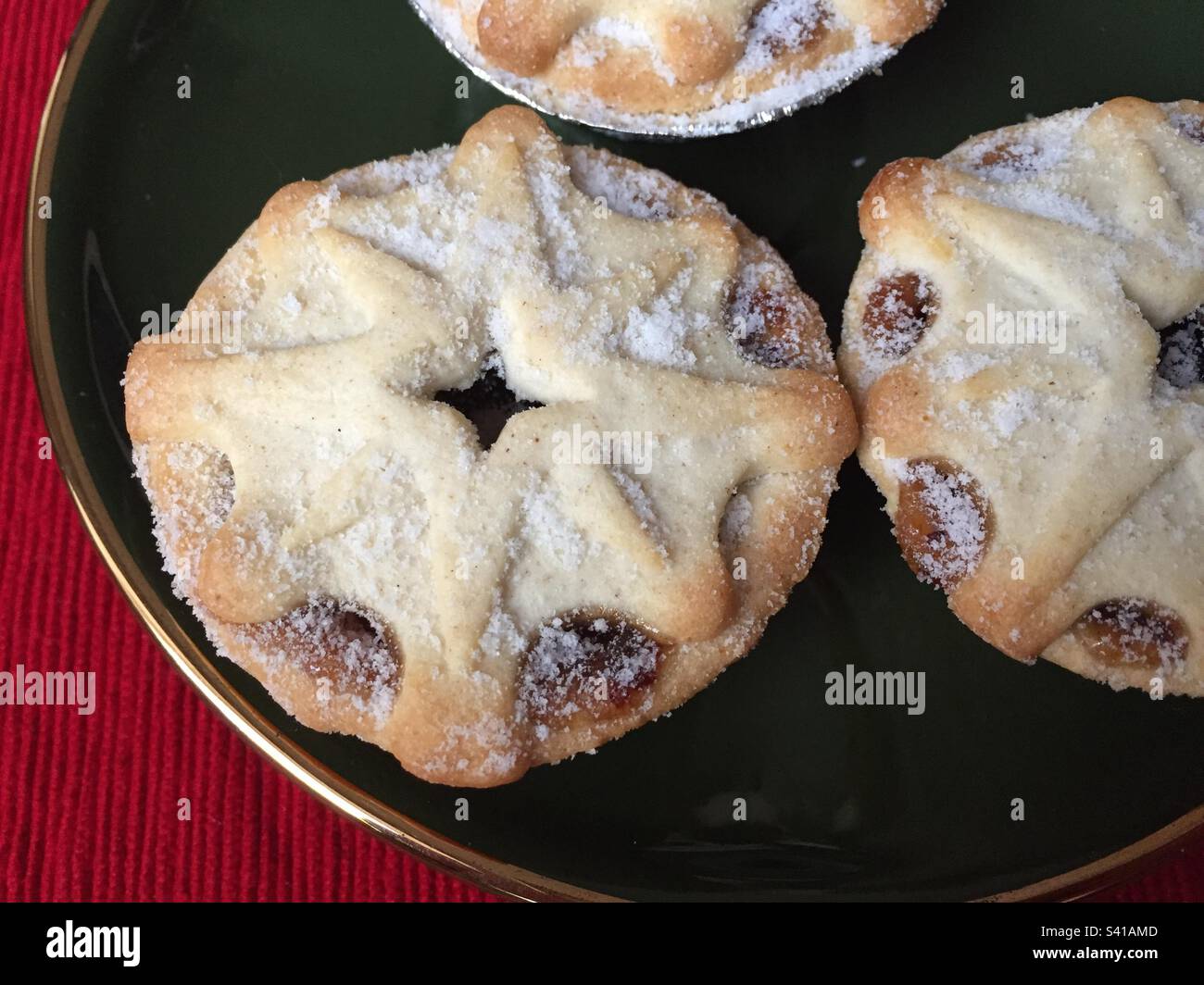 Mince pies on a dark green plate with a gold rim, traditional Christmas treats, pic 6. - Smartphone Captured Stock Image