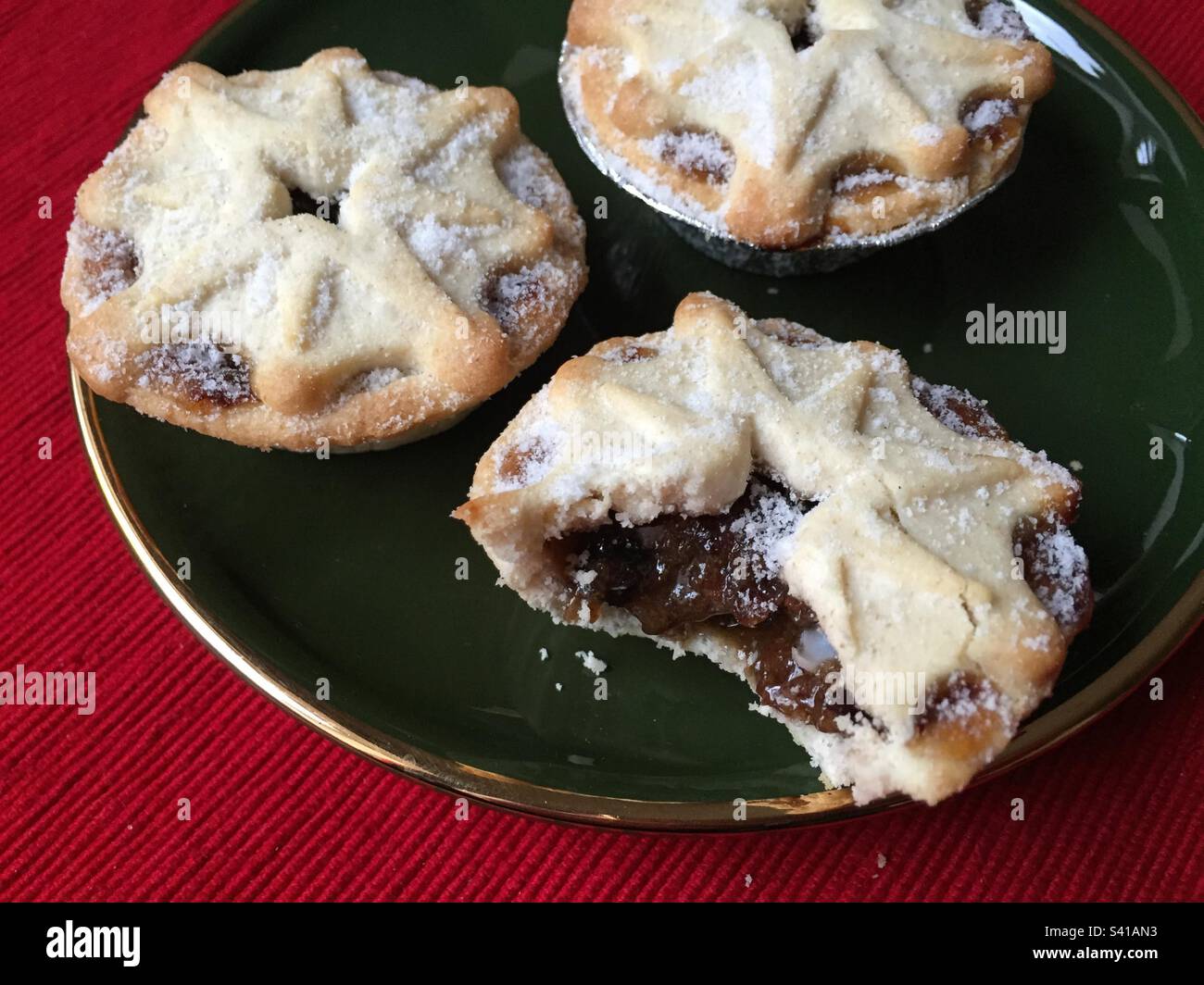 Mince pies on a dark green plate with a gold rim, traditional Christmas treats, pic 12. - Smartphone Captured Stock Image