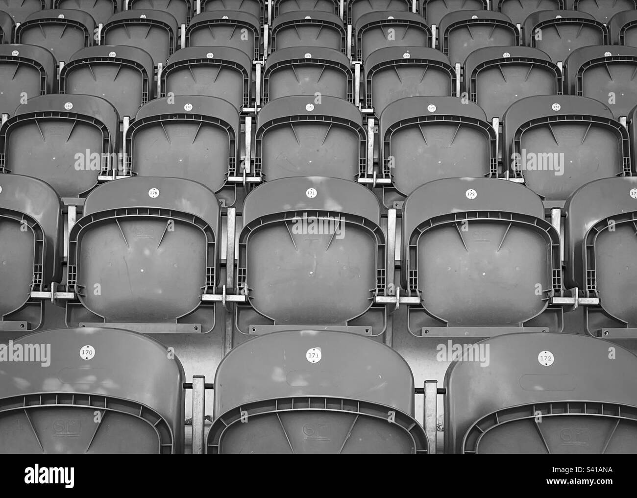 ‘Enjoy the game’ sports stadium, empty seats with no supporters (Black & White) Stock Photo