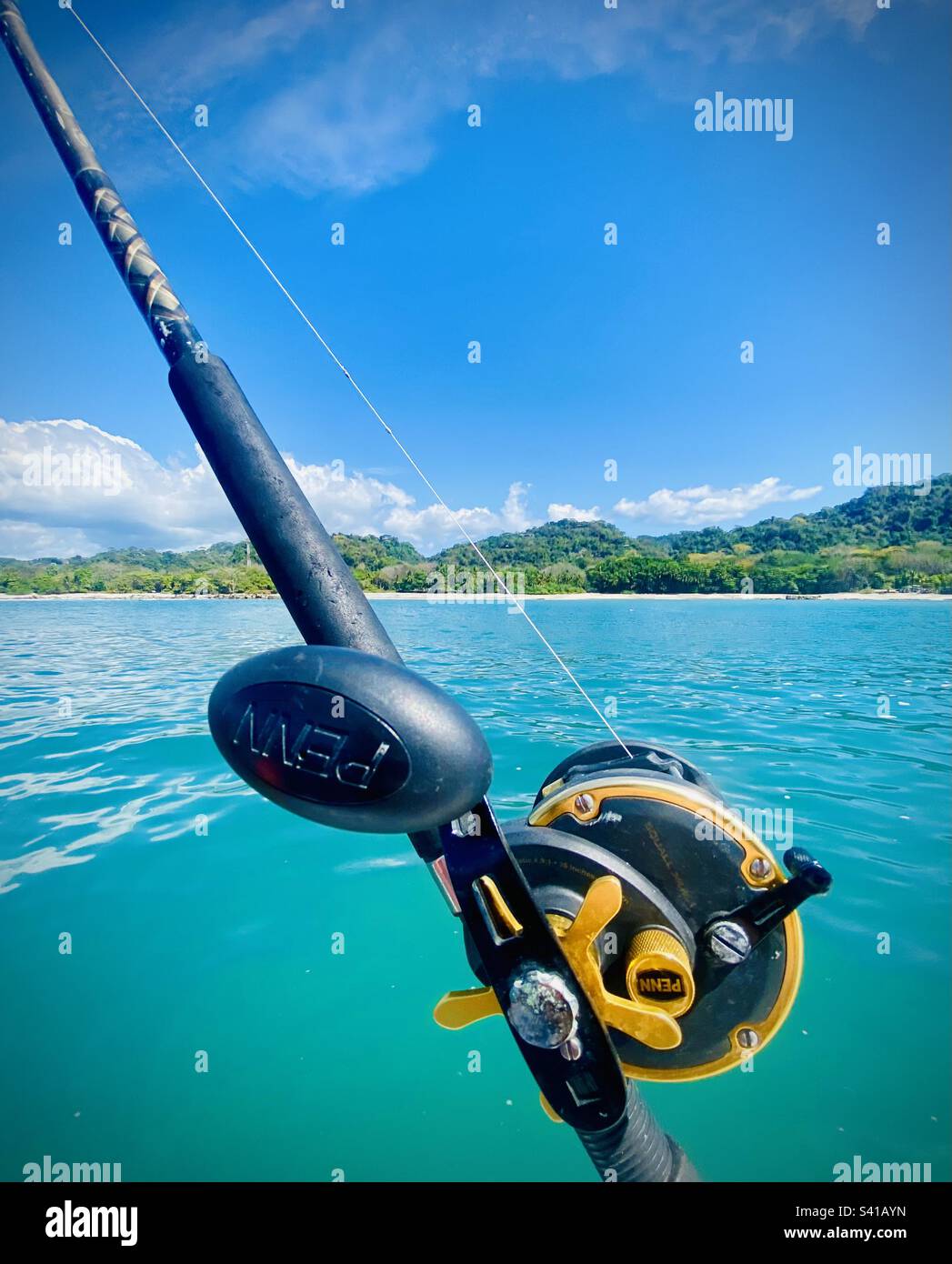 A fishing rod and reel near a tropical beach in Costa Rica - Smartphone Captured Stock Image