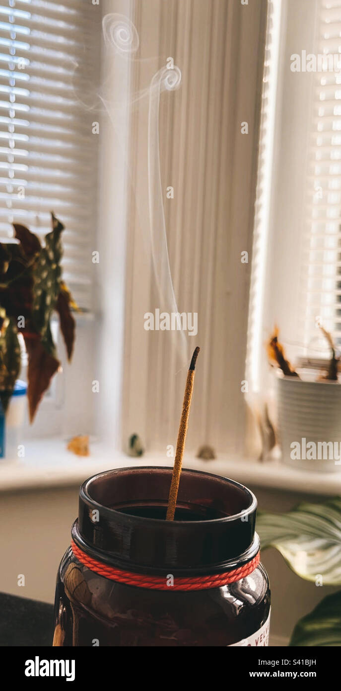 Burning incense stick creating spirals Stock Photo Alamy