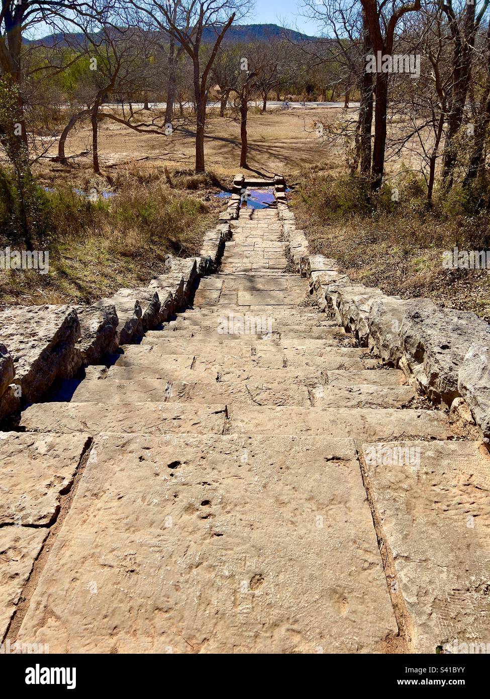 Limestone staircase leading to a creek through the woods towards a ...