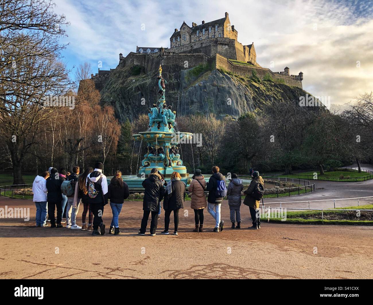 Tour guide with tourist party at the Ross fountain, Princes Street Gardens, with Edinburgh Castle as a backdrop Stock Photo