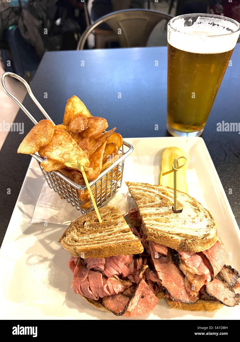 Montreal smoked meat toasted sandwich on rye bread, fried potato chips