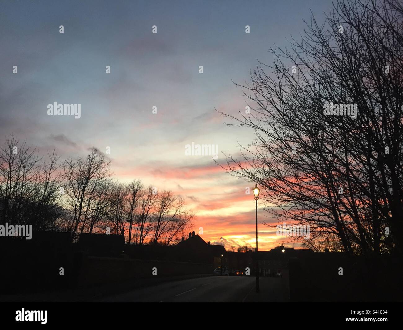 Sunset, Colourful sky with silhouetted trees, rooftops and lamp posts. UK, January 2023 pic 5. - Smartphone Captured Stock Image