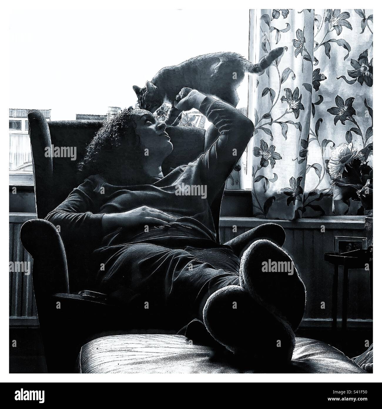 A woman at home with her pet cat. - Smartphone Captured Stock Image