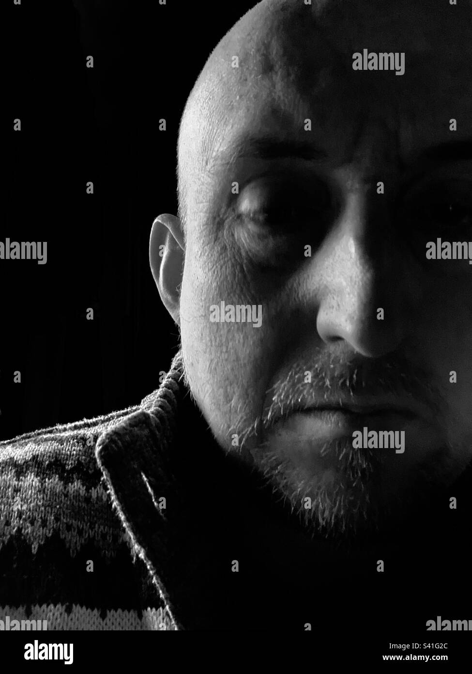 Middle aged man, lit from the side showing in back and white. - Smartphone Captured Stock Image