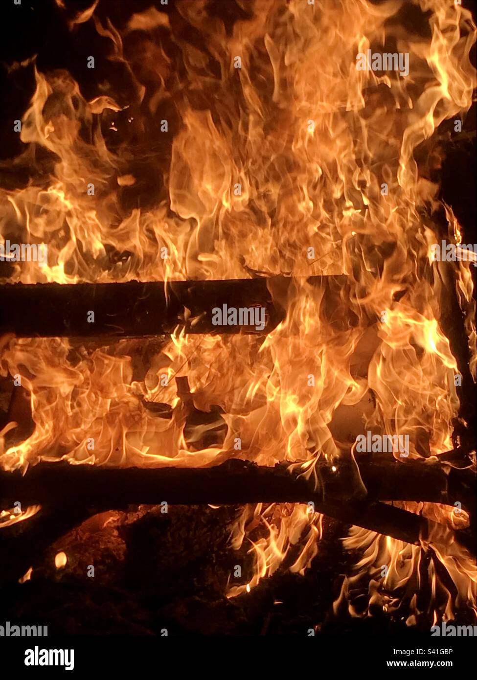 Close up of flames and wood in burning fire - Smartphone Captured Stock Image