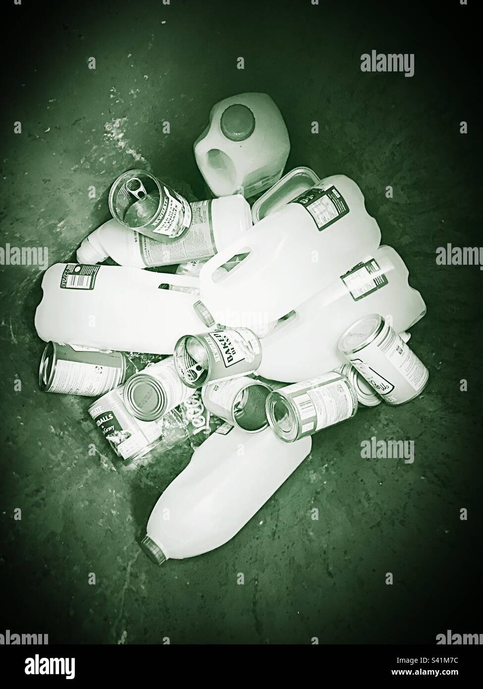 Plastics and tins in the bottom of a recycling bin ready for collection