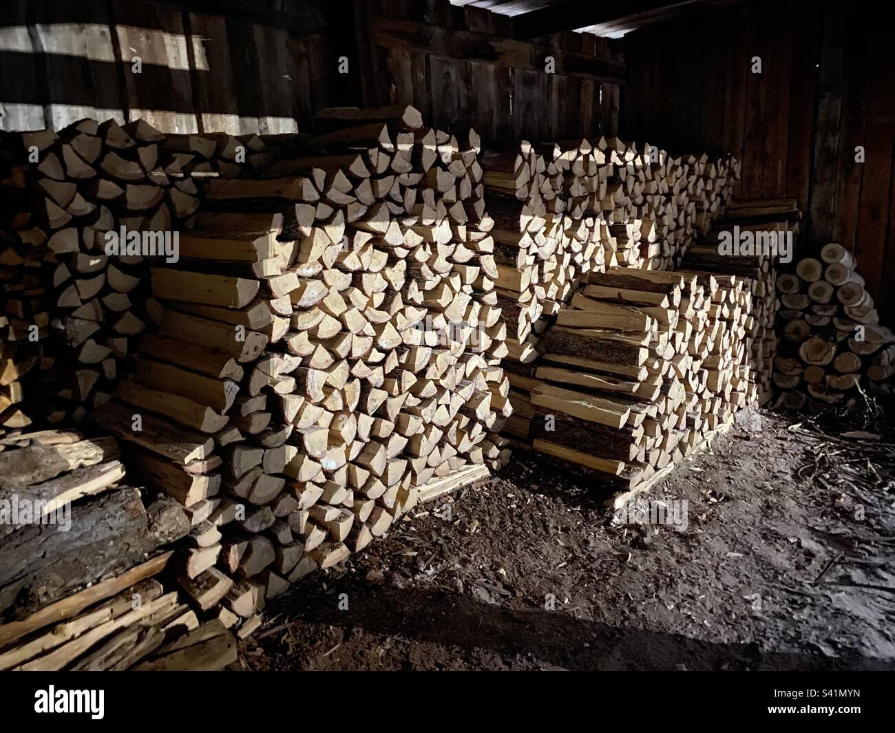 Clearly stacked firewood lies in the shade in winter in Yakutia. - Smartphone Captured Stock Image