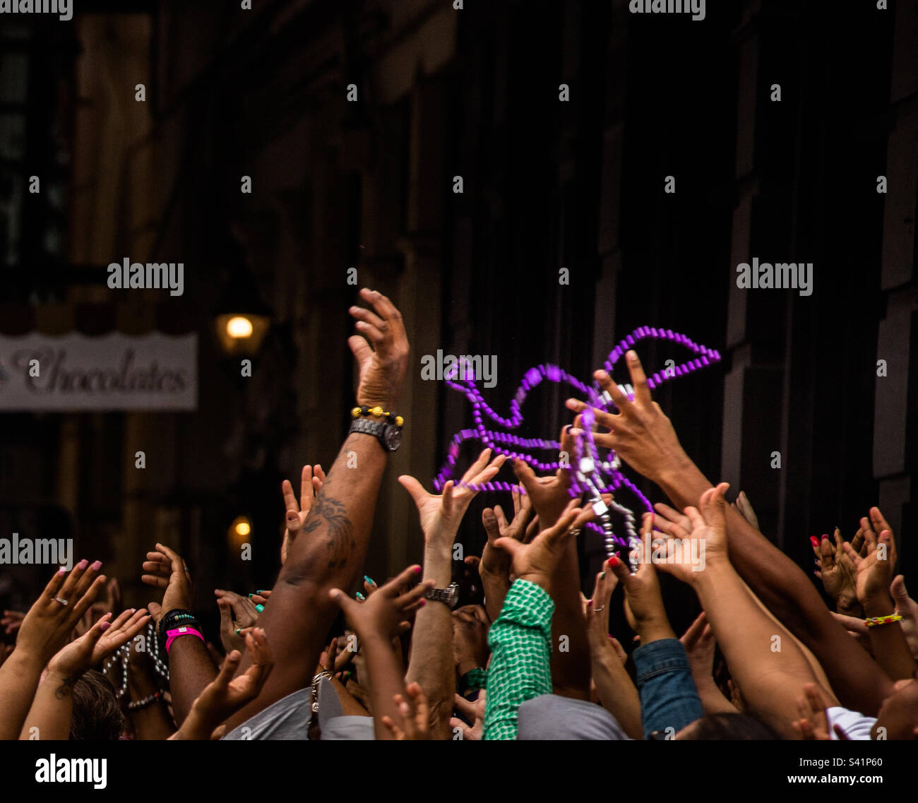 Hands grasping at beads during Mardi Gras parade in New Orleans Stock Photo