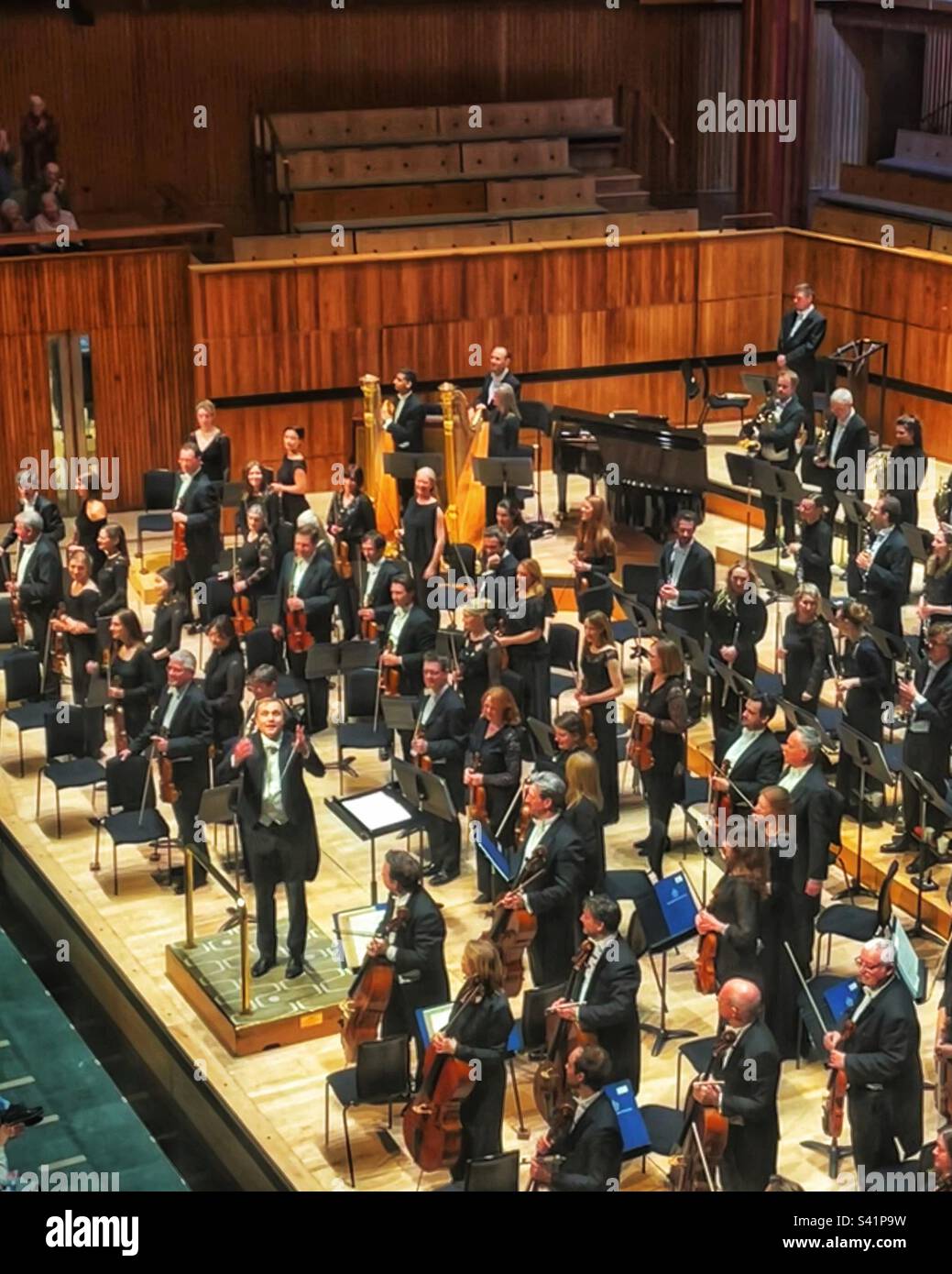 Vasily Petrenko takes the applause at the Royal Festival Hall after conducting a wonderful performance by the Royal Philharmonic Orchestra in London SE1 - Smartphone Captured Stock Image
