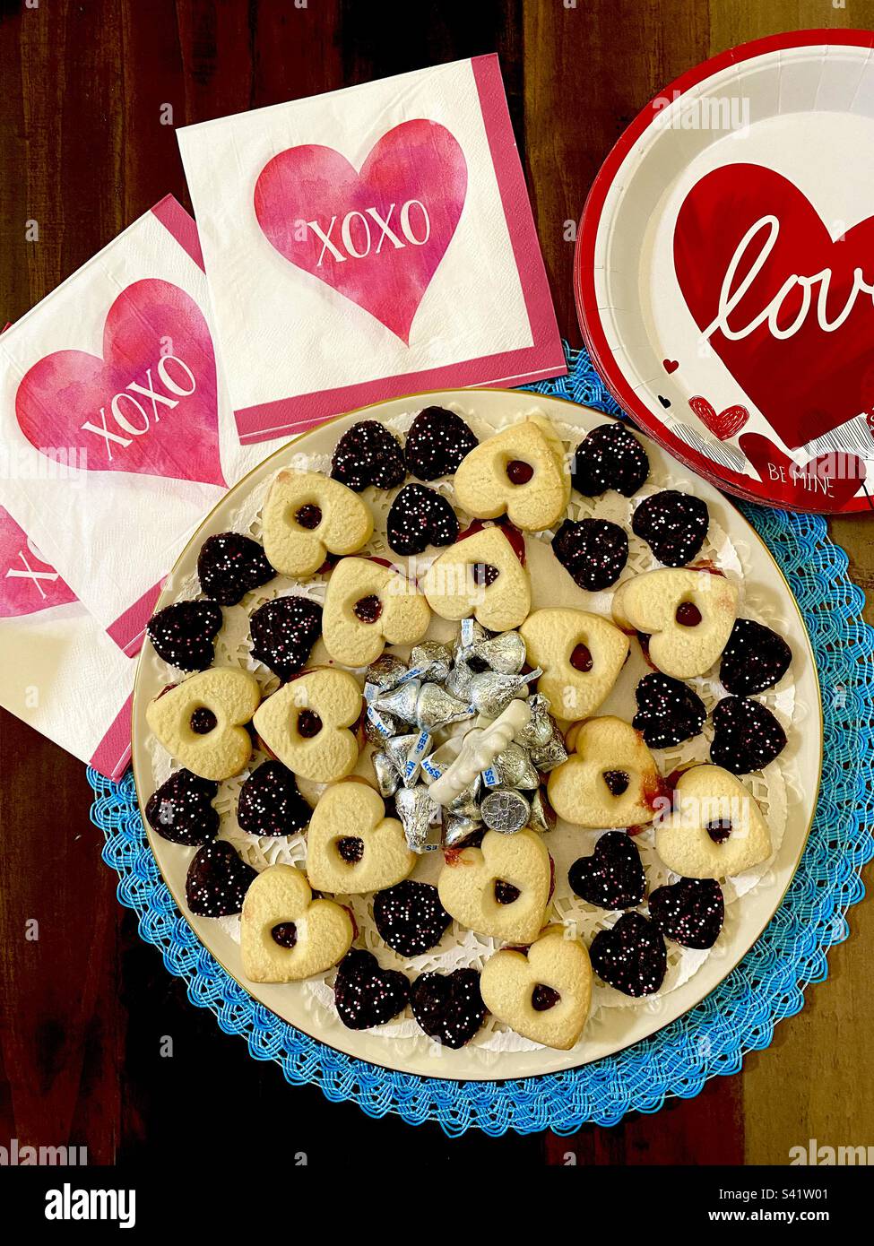 A spread of Valentine’s Day cookies and candies with napkins and plates that say Love. - Smartphone Captured Stock Image