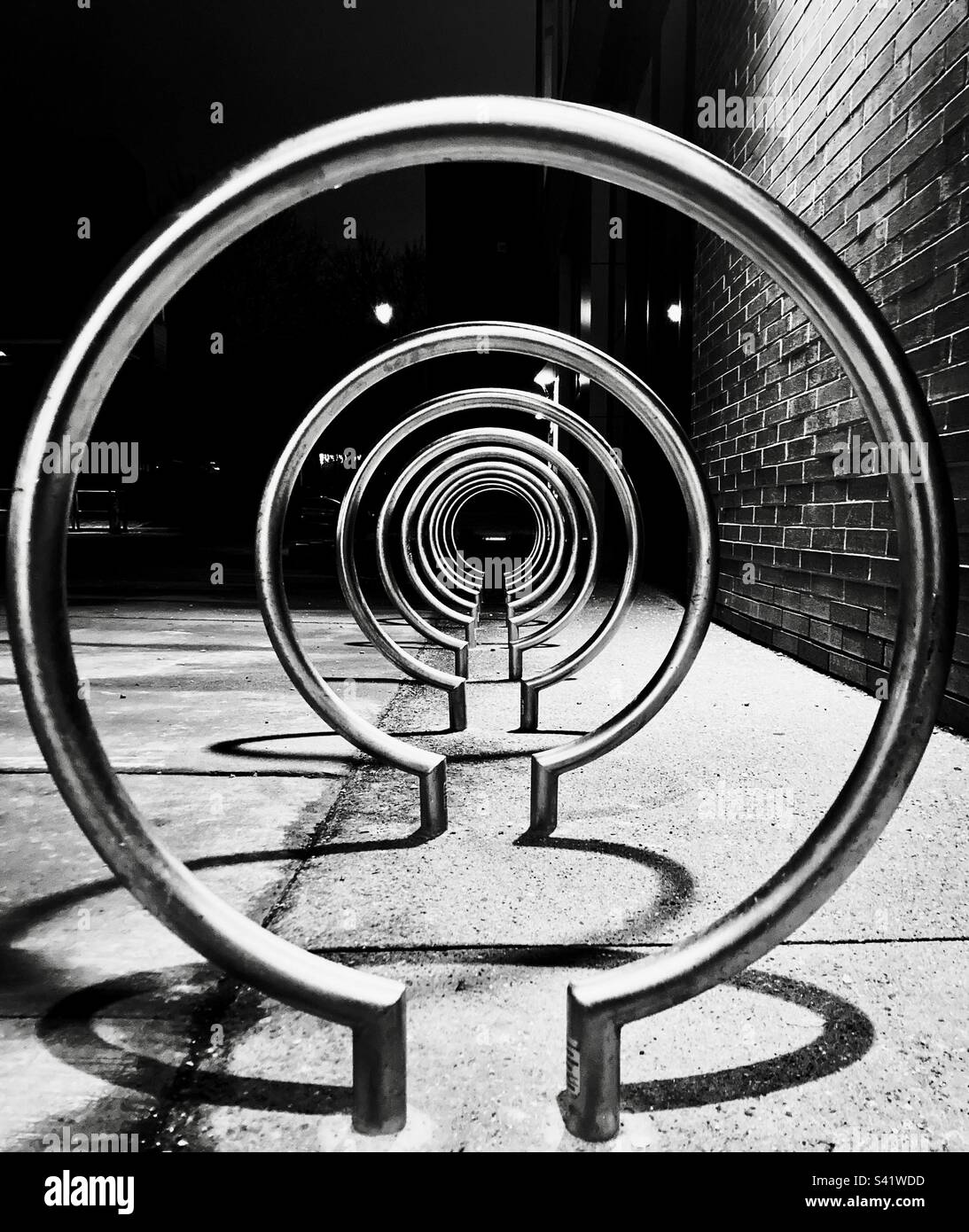 Circular bike rack creates patterns and shadows. - Smartphone Captured Stock Image