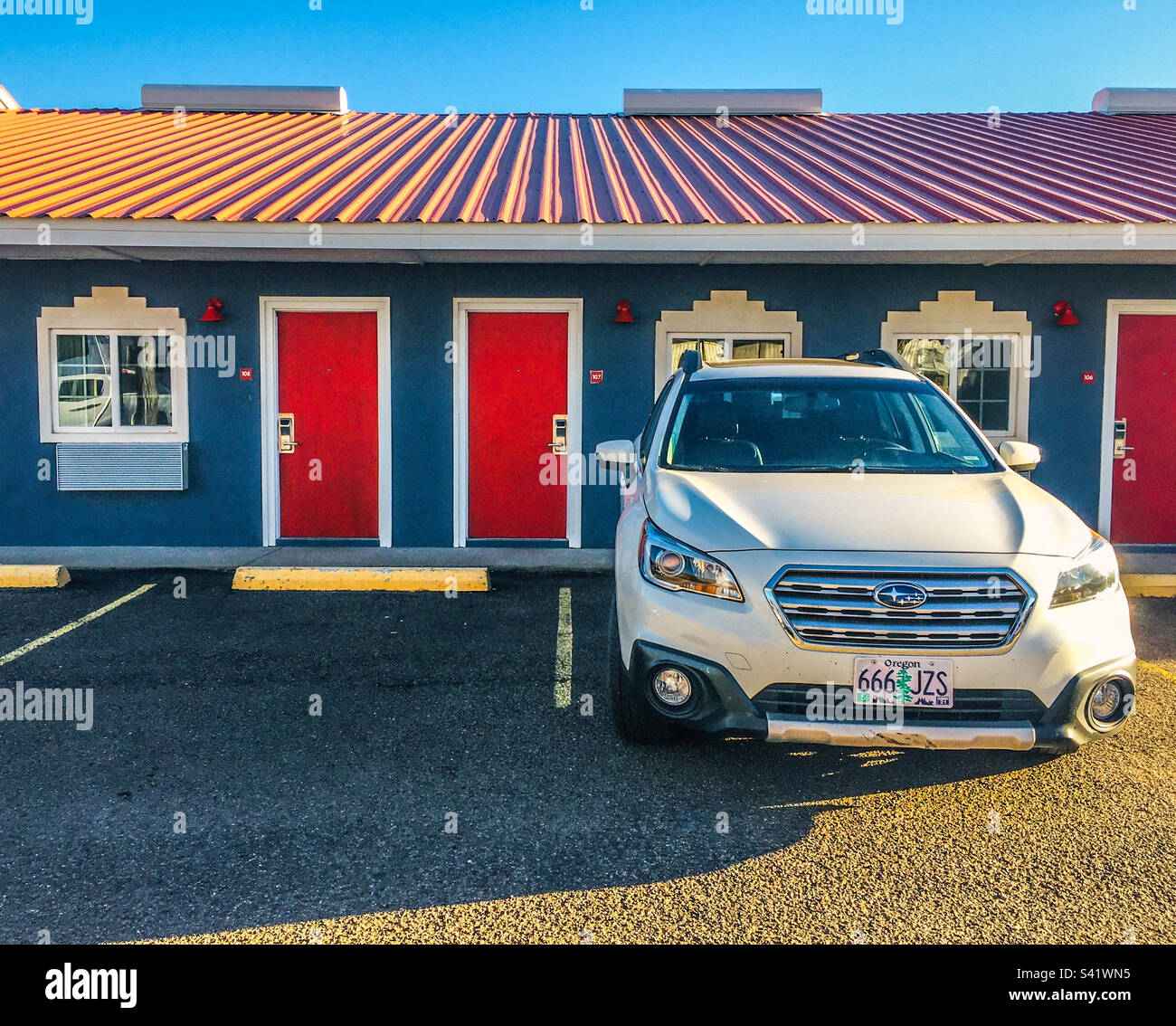 A white car parked outside a colourful motel in Texas USA - Smartphone Captured Stock Image