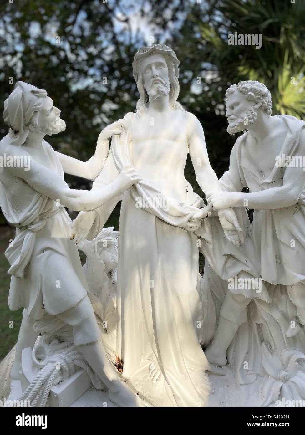 Jesus stripped of his garments, stations of the cross, white nearly life-size statues, 10th station, portrait mode Stock Photo