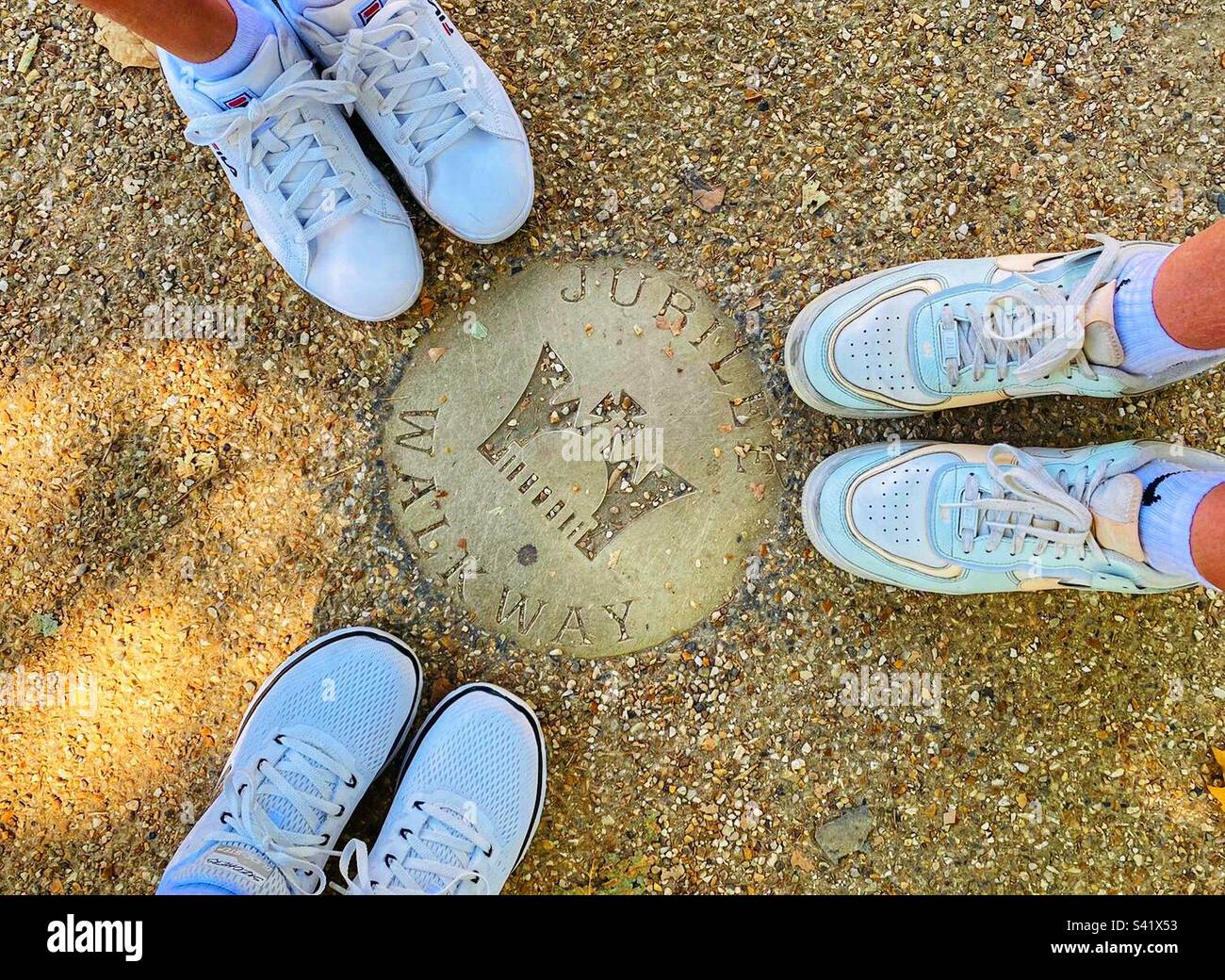Three tourists with white shoes exploring the Jubilee Walk near Buckingham Palace - Smartphone Captured Stock Image