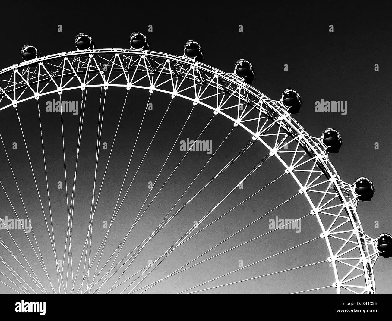 Black and white photo of a section of the London Eye on a cloudless day - Smartphone Captured Stock Image