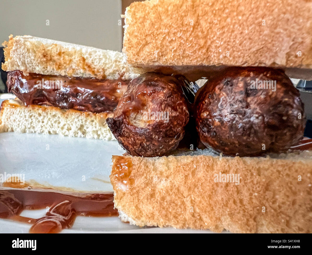 Sausage sandwich on white bread with brown sauce Stock Photo Alamy