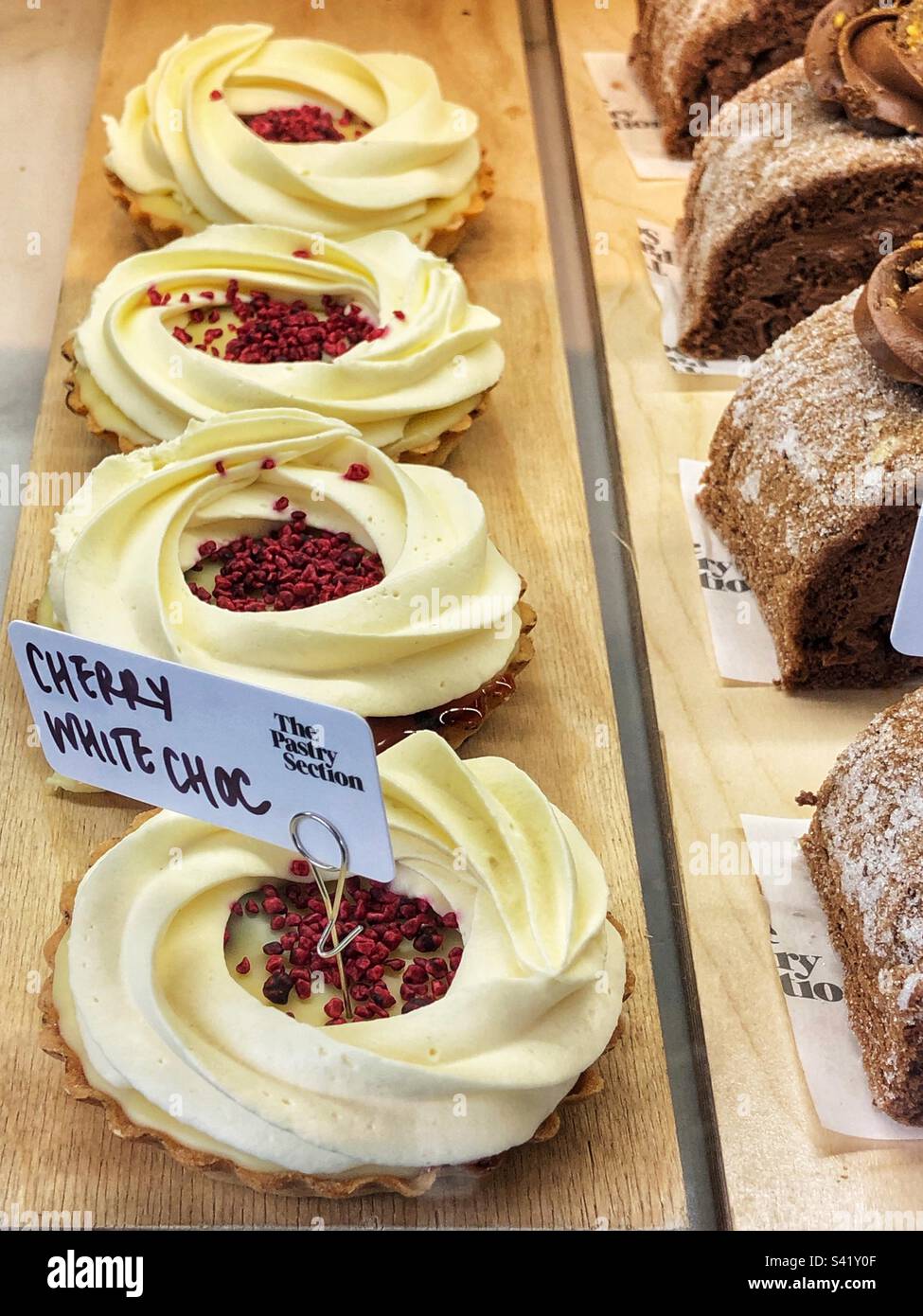 Cherry white chocolate tart in bakery window - Smartphone Captured Stock Image