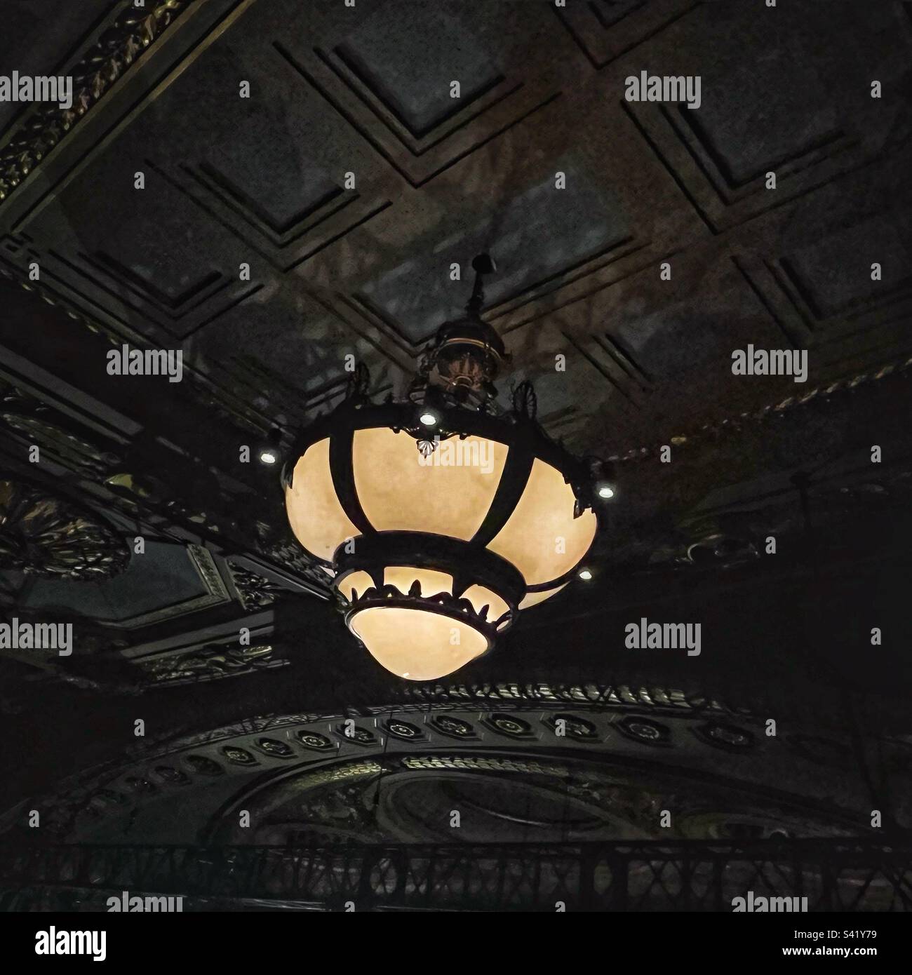 Decorative lighting hangs from the ceiling of the Theatre Royal, Drury Lane in London. - Smartphone Captured Stock Image
