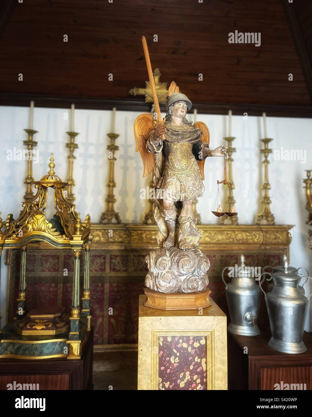 Archangel St Michael, surrounded by historic church artefacts like feet washing jugs seen in the 17th century Chapel at Faro Sé in Portugal - Smartphone Captured Stock Image
