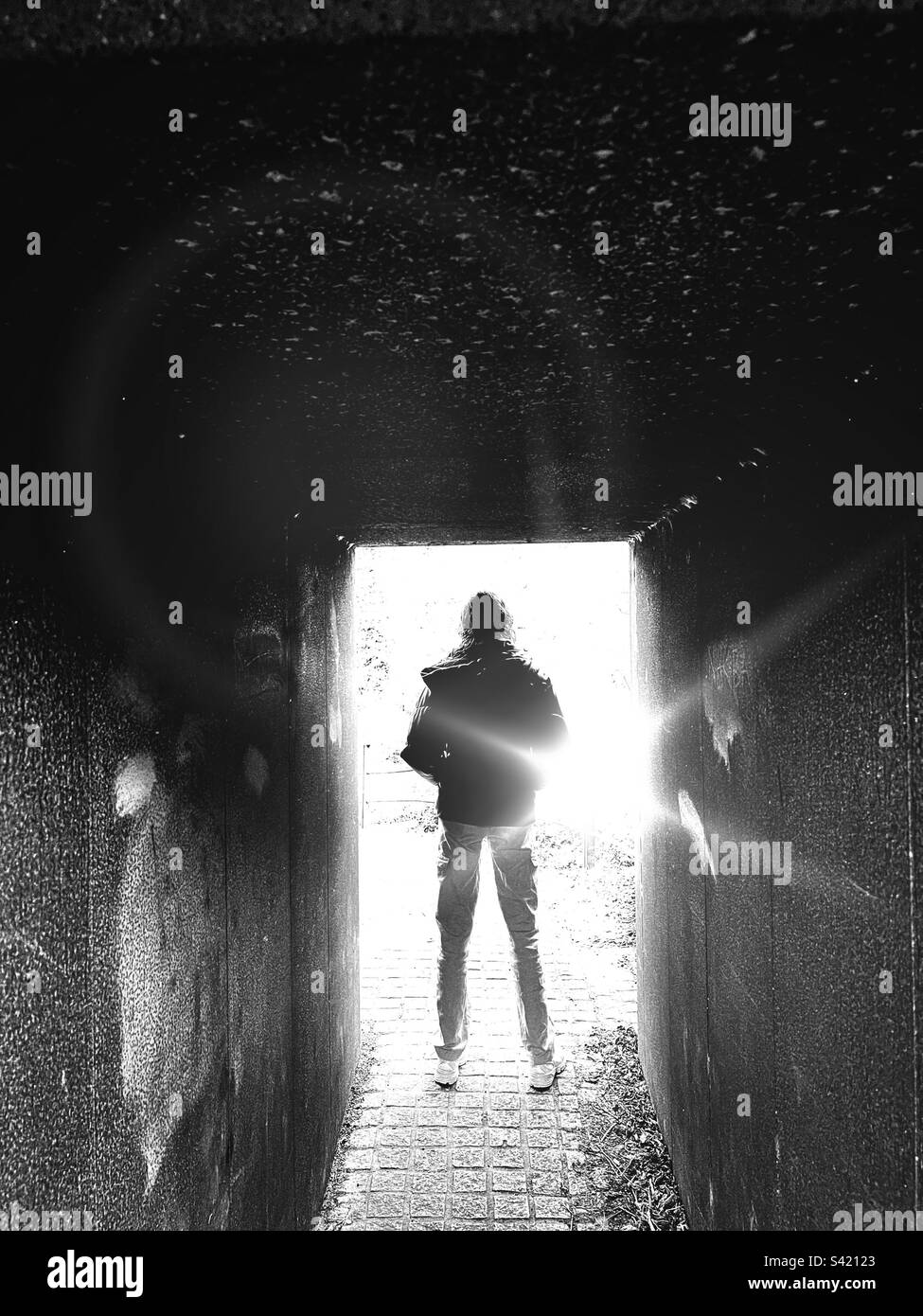 Girl standing in tunnel in silhouette against a bright light - Smartphone Captured Stock Image