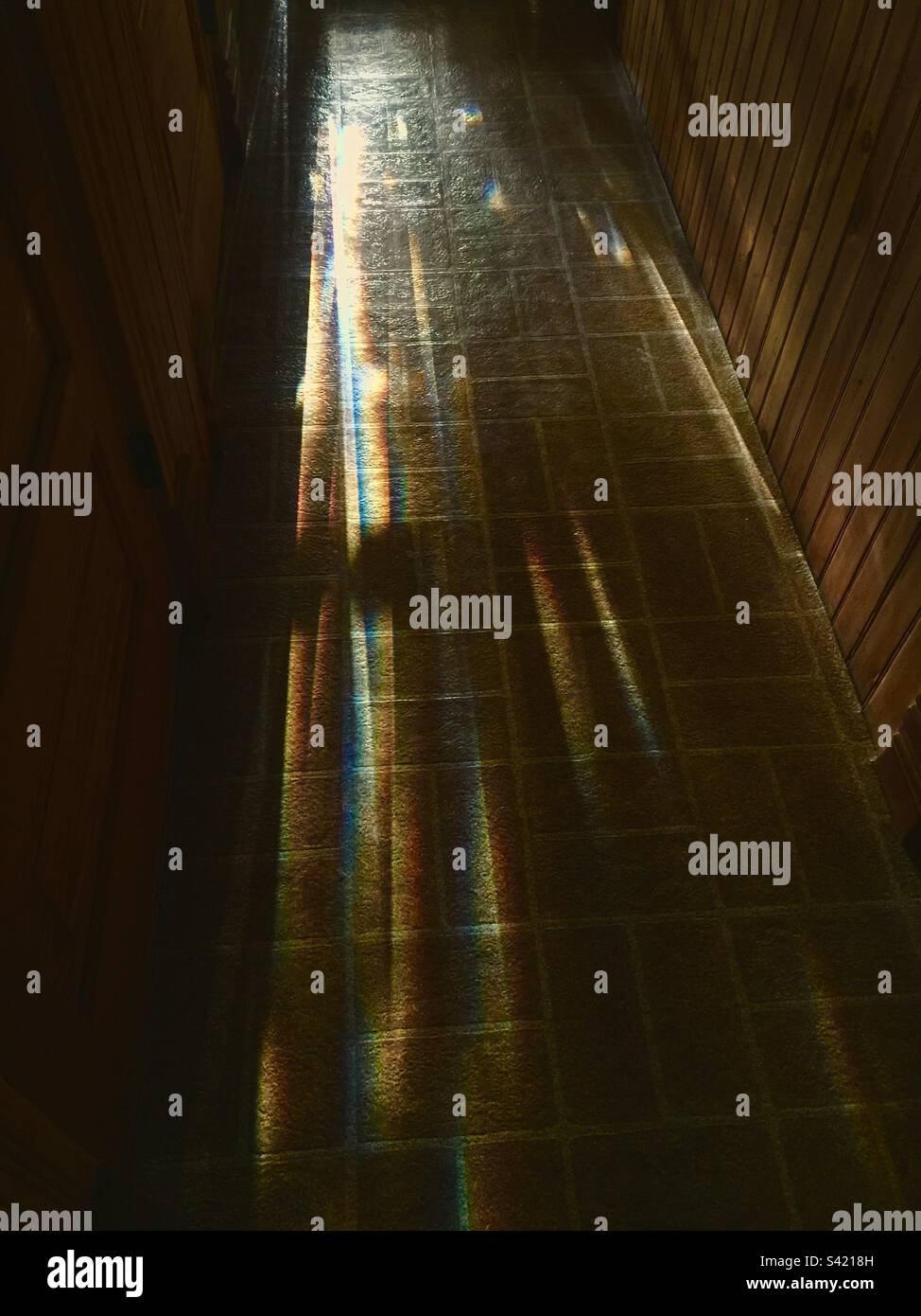 Long Shadows in an elegant, enclosed hallway, Ontario, Canada. Light at the end. - Smartphone Captured Stock Image