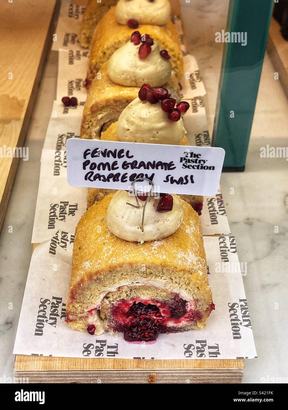 Fennel Pomegranate Raspberry Swiss roll in bakery window - Smartphone Captured Stock Image