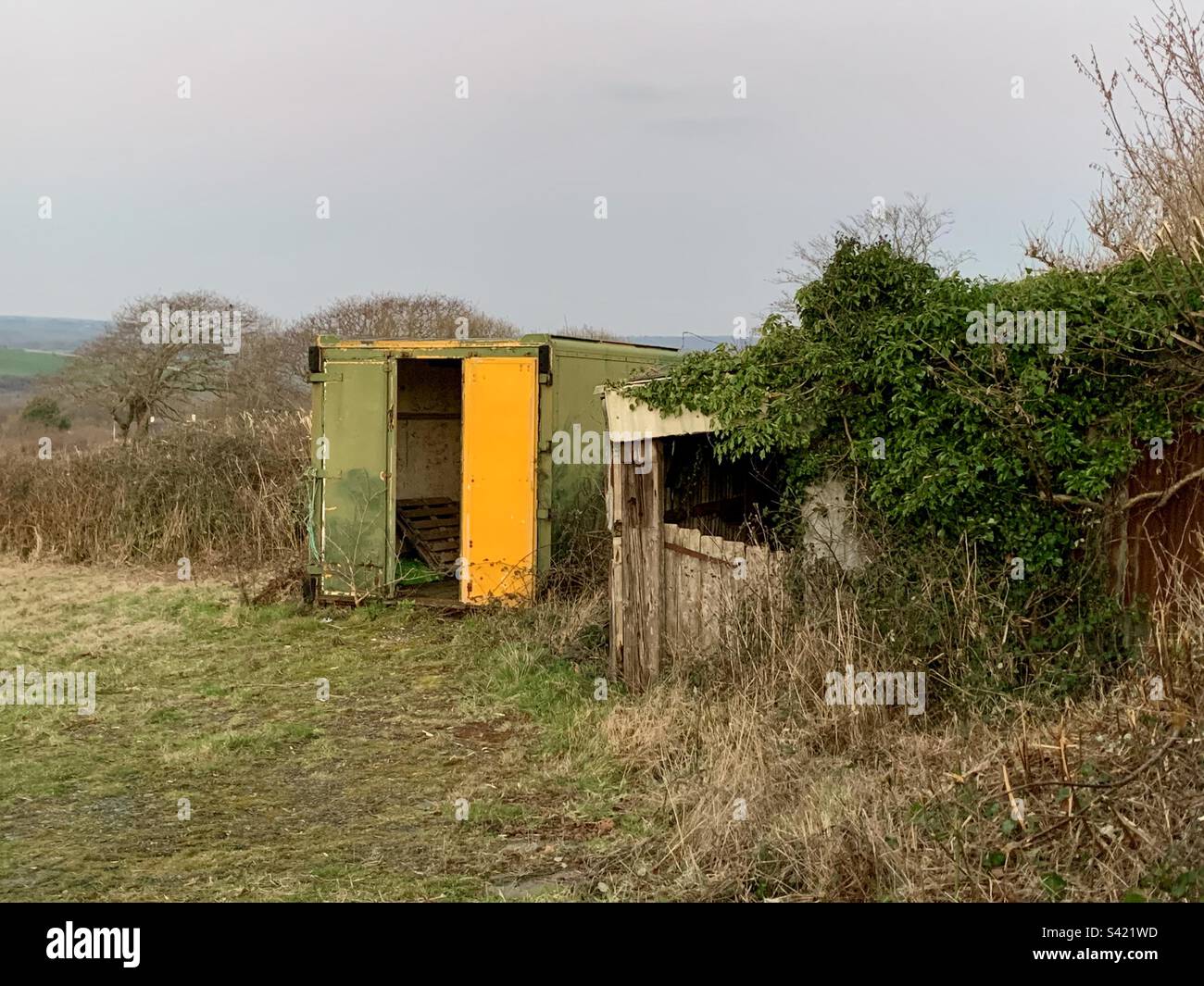 Green and yellow tin hut and abandoned farm land Stock Photo Alamy