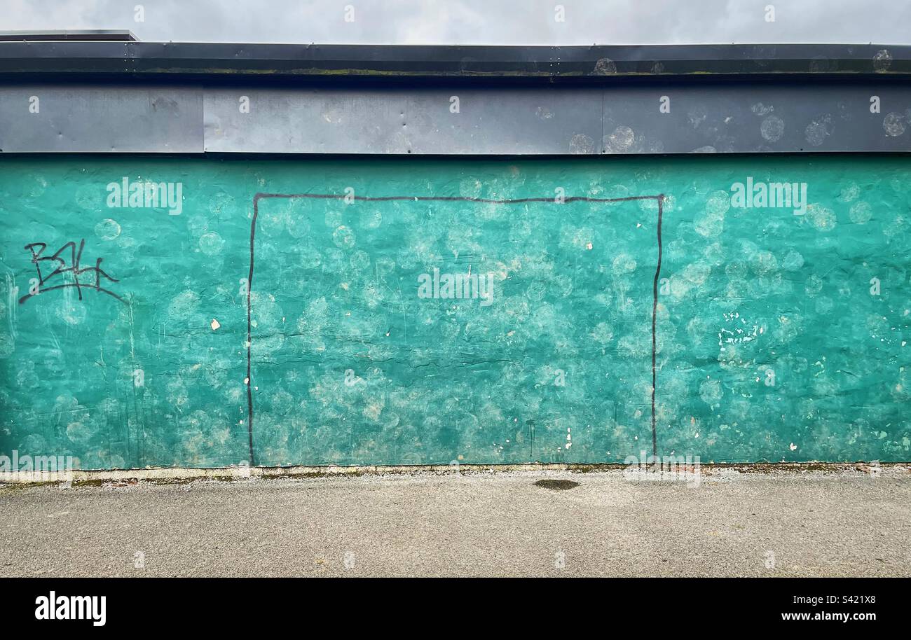 ‘Shifting the goalposts’ hand drawn goalposts, graffitied onto a wall. Muddy ball marks from shots (some on target, some not) are left behind from games gone by. Stock Photo