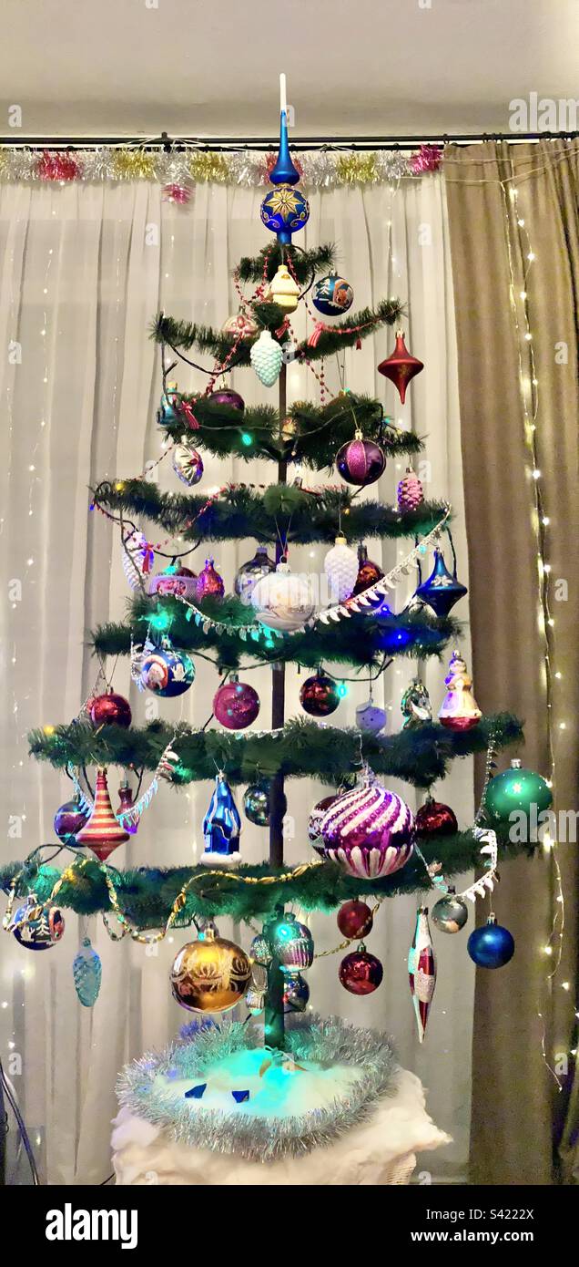 Christmas artificial Christmas tree stands decorated with balloons in the apartment of Russia. - Smartphone Captured Stock Image