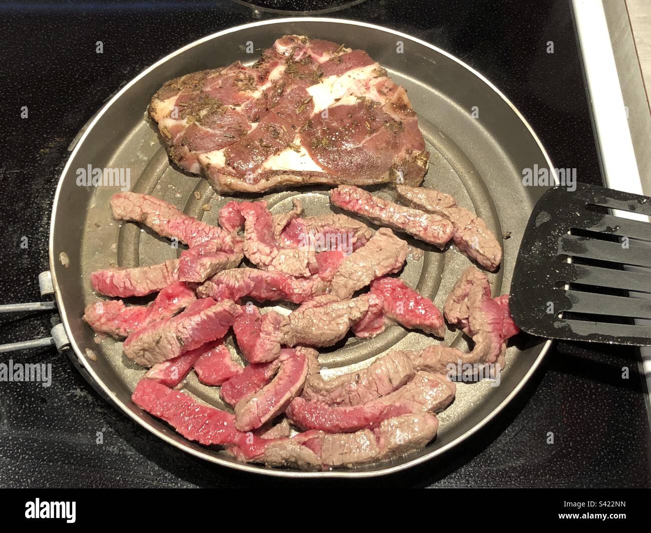 A lamb chop and beef cuts in the frying pan Stock Photo Alamy