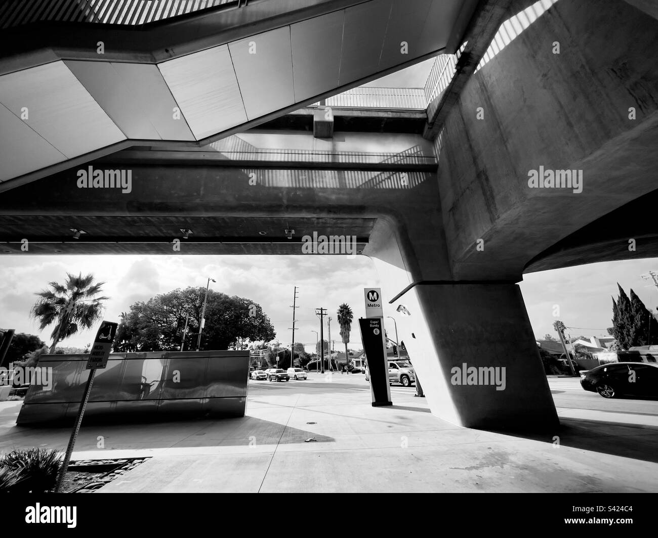 LOS ANGELES, CA, NOV 2022: Black and white view of concrete architecture underneath Bundy Station on the LA Metro Expo Line, next to street with passing traffic - Smartphone Captured Stock Image