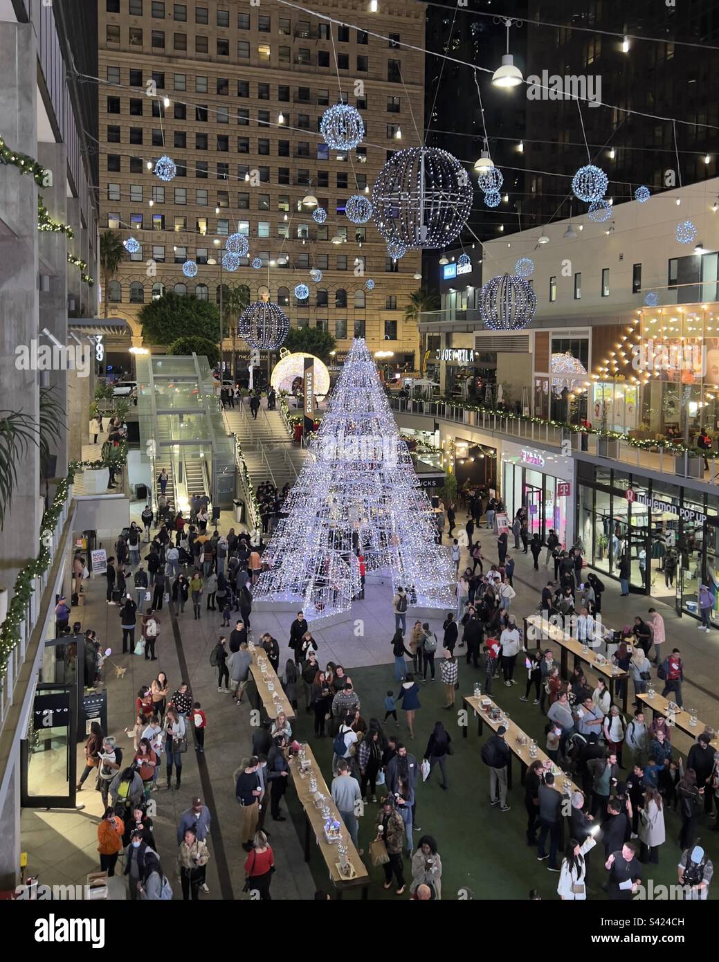 LOS ANGELES, CA, NOV 2022: high angle view over holiday decorations and people gathered for carol singing at The Bloc in Downtown - Smartphone Captured Stock Image