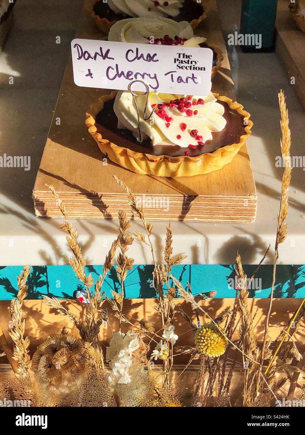 Dark chocolate Cherry tarts in bakery window - Smartphone Captured Stock Image