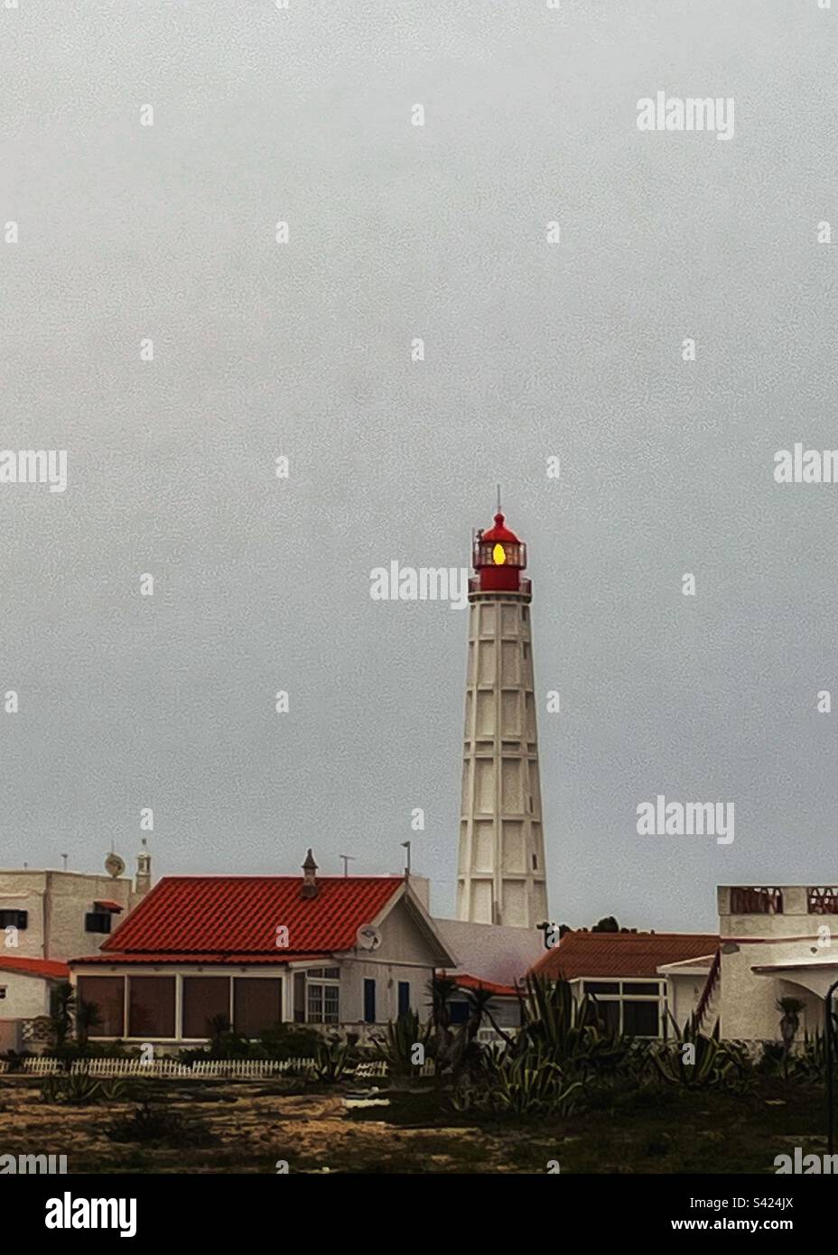 Light shining from the lighthouse - view shows fisherman village on Ilha do Farol in Portugal. Culatra Island, Atlantic Ocean and estuary of the Ria Formosa - Smartphone Captured Stock Image
