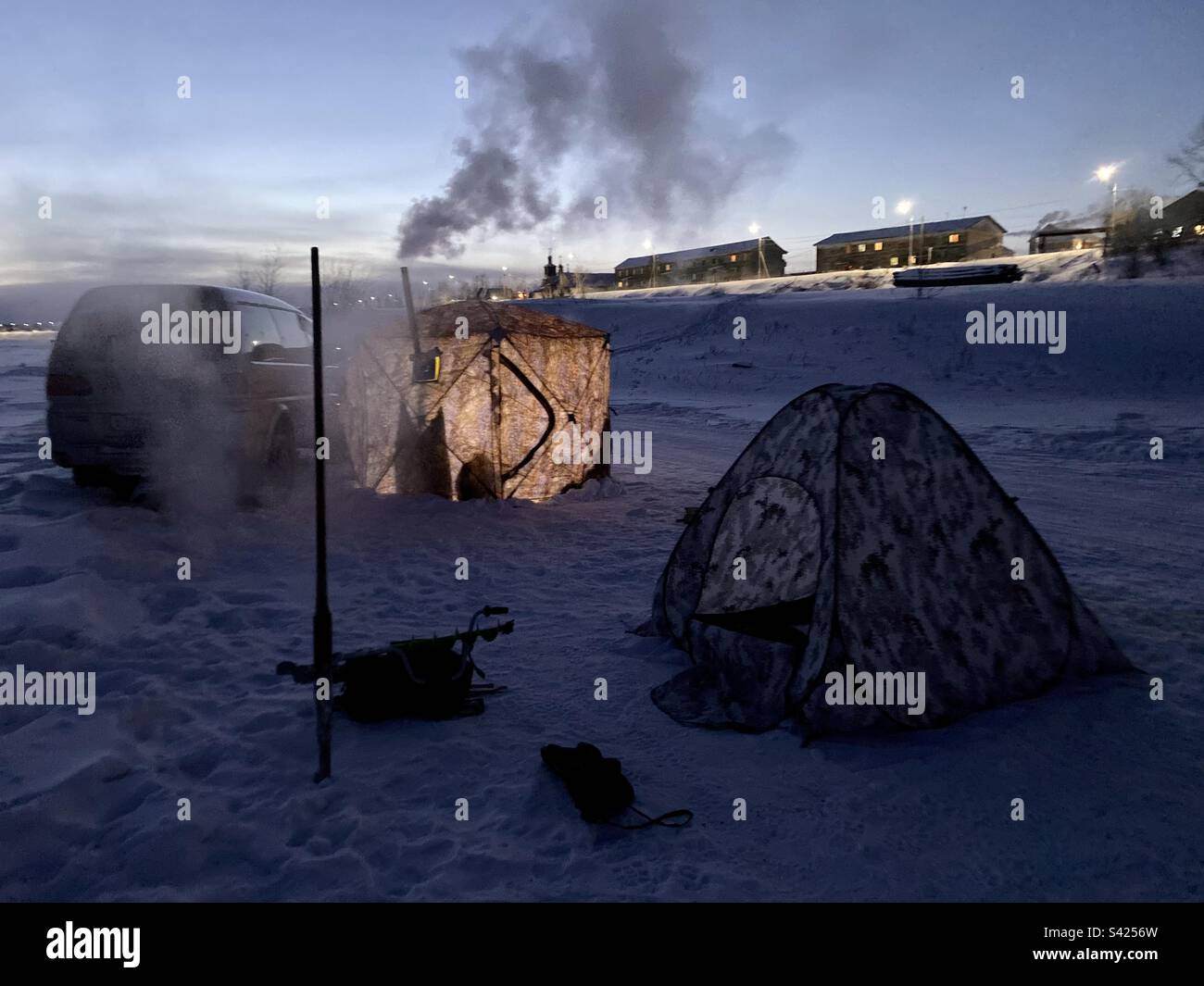 Night fishing in winter in tents small and large with a stove and a car in Yakutia. - Smartphone Captured Stock Image
