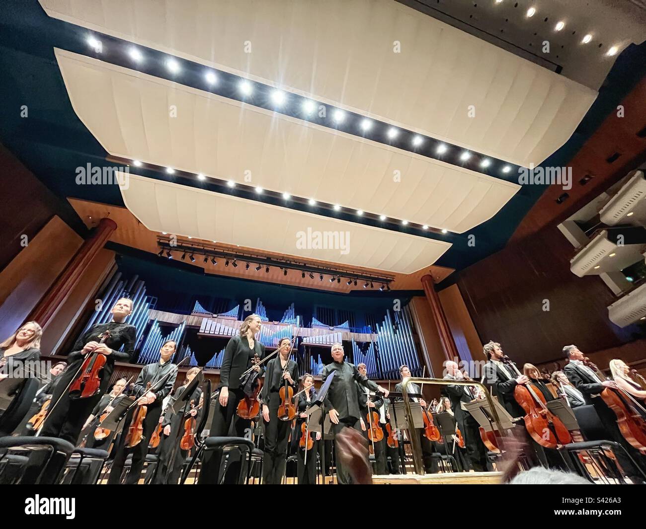 Bertrand de Billy takes the applause with the London Philharmonic Orchestra at the Royal Festival Hall in London - Smartphone Captured Stock Image
