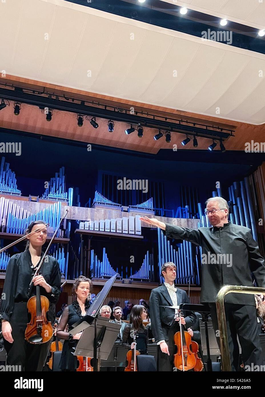 Bertrand de Billy takes the applause with the London Philharmonic Orchestra at the Royal Festival Hall in London close up - Smartphone Captured Stock Image