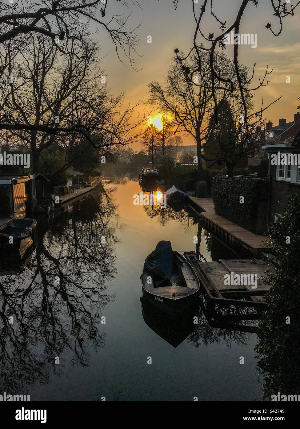 Idilyc sunrise in a Dutch canal surrended by boats and floating houses - Smartphone Captured Stock Image