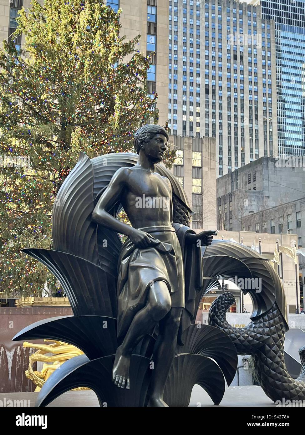 Statue at Rockefeller Center in New York with the big Christmas tree in