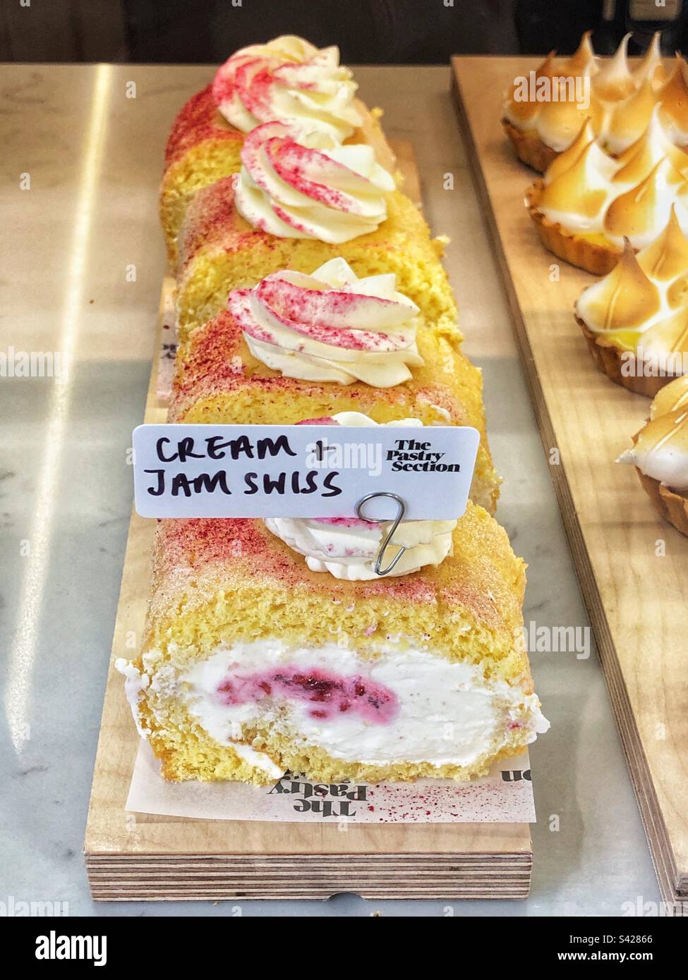 Cream and Jam Swiss roll in bakery shop window - Smartphone Captured Stock Image