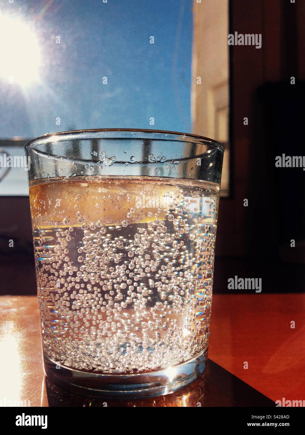 A glass of sparkling water served with a slice of lemon - Smartphone Captured Stock Image