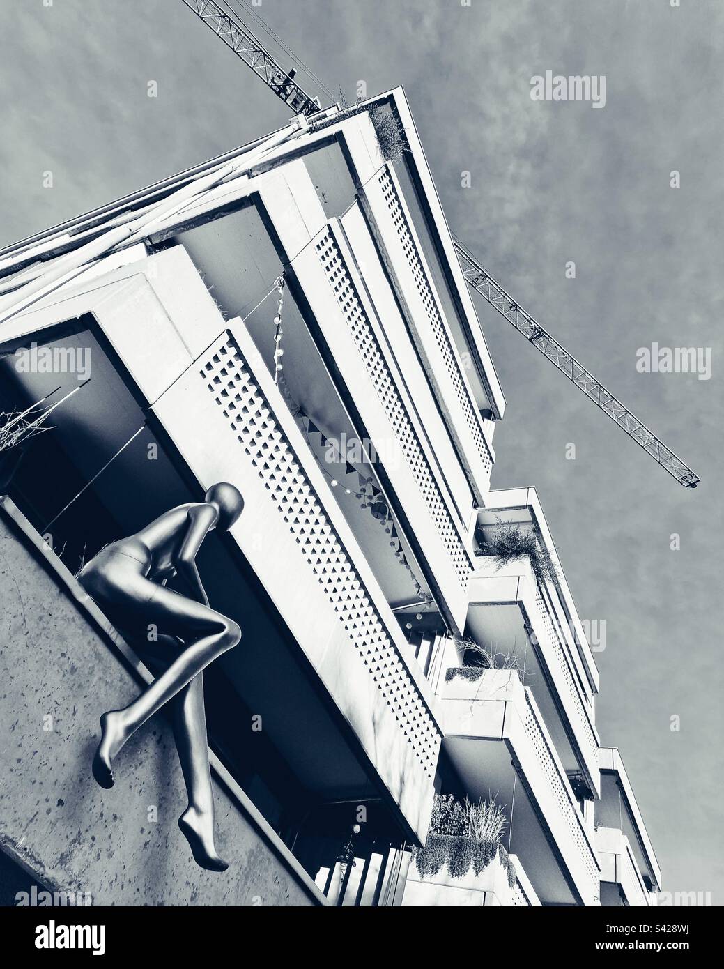 Model tenant - shop dummy on balcony of 1960s apartment block, Switzerland - Smartphone Captured Stock Image