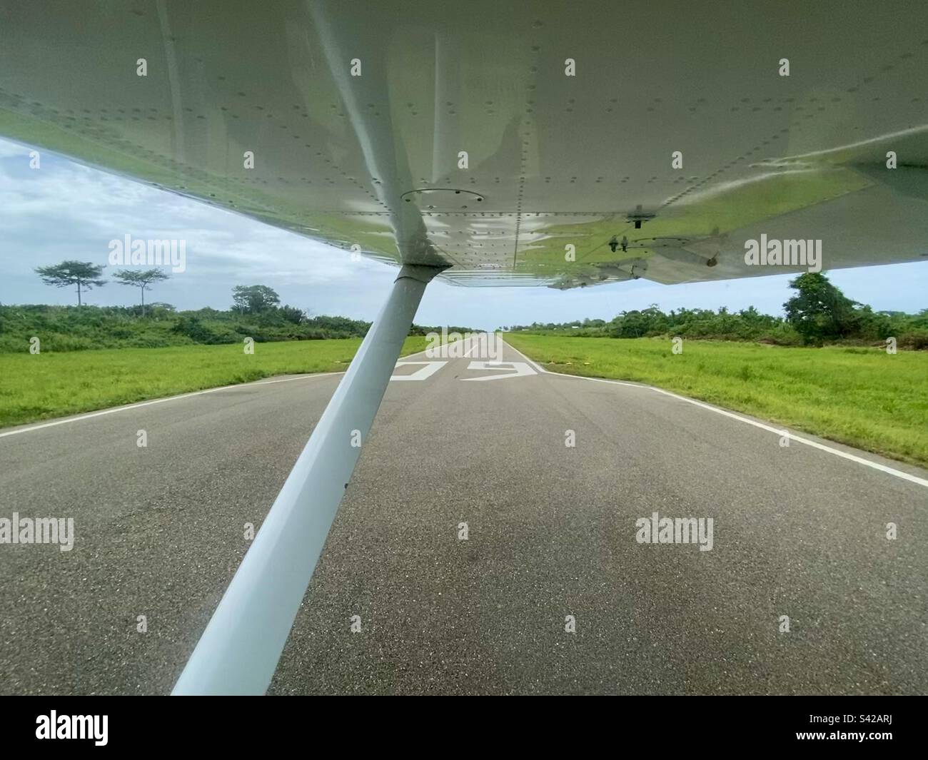 Looking out from a small airplane down the runway of Dangriga Airport in Belize - Smartphone Captured Stock Image