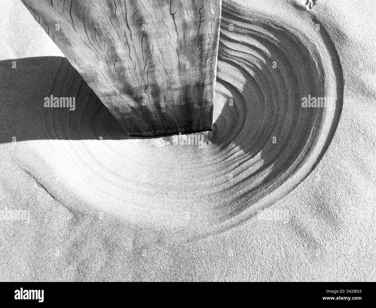 Sunlight and Ripples Around a Wooden Pole on the Beach - Smartphone Captured Stock Image