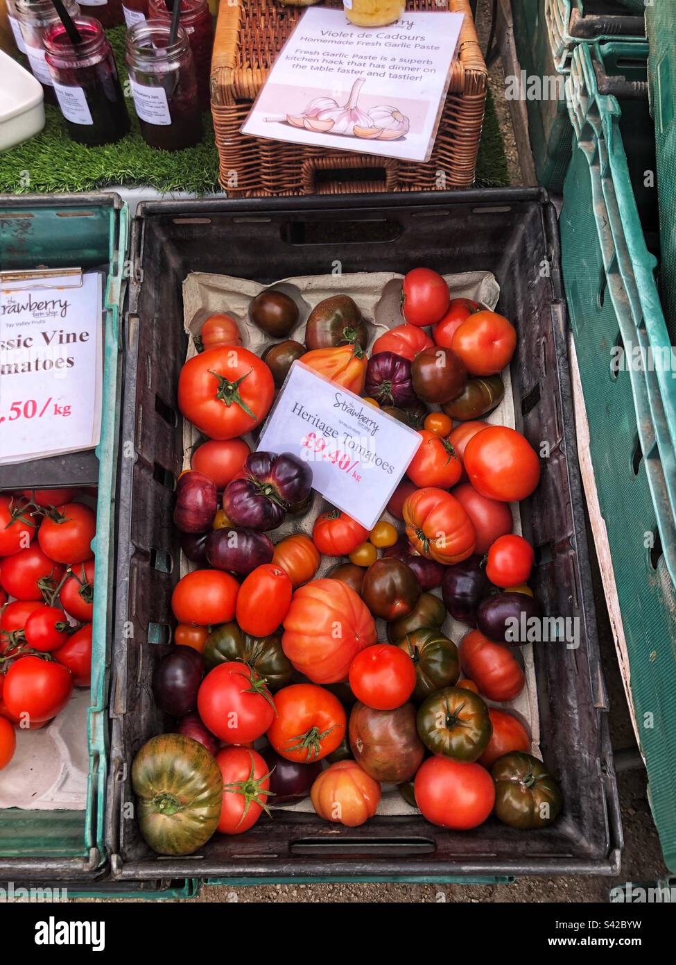 Speciality Heritage tomatoes varieties priced up for sale at local farmers market - Smartphone Captured Stock Image